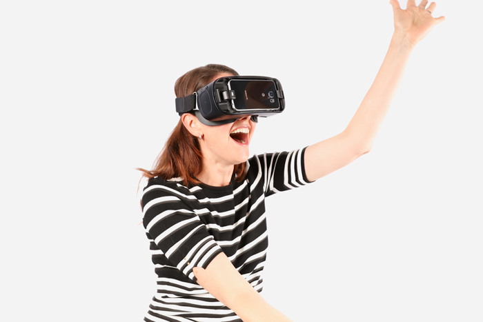 A woman uses a smartphone-based virtual reality headset.