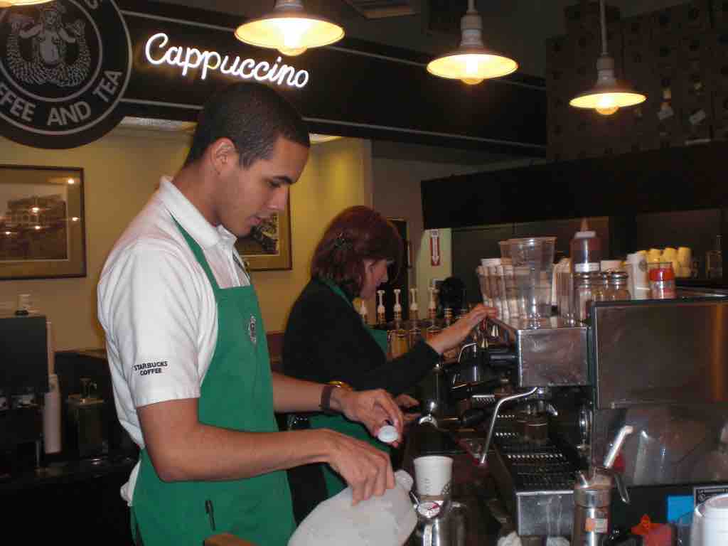 A picture of baristas at work in the first Starbucks coffee shop, Seattle, WA.