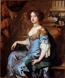 portrait of a woman with brown hair in a blue-and-gray dress